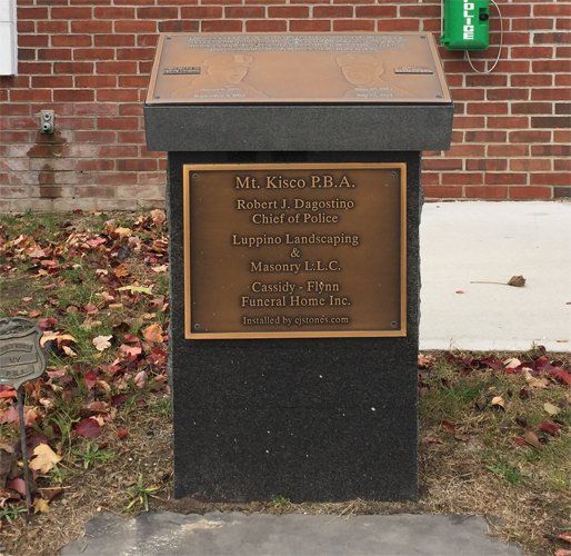 A granite civic memorial with bronze plaques for the Mt. Kisco Police Benevolent Association