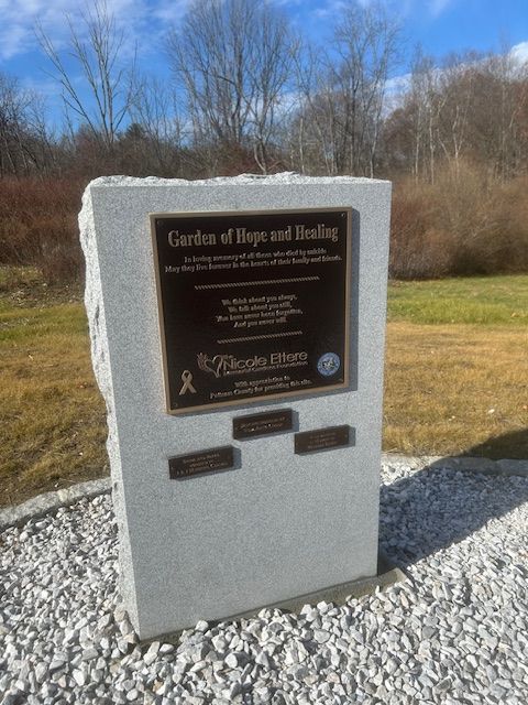 A granite memorial with a bronze plaque reading Garden of Hope and Healing