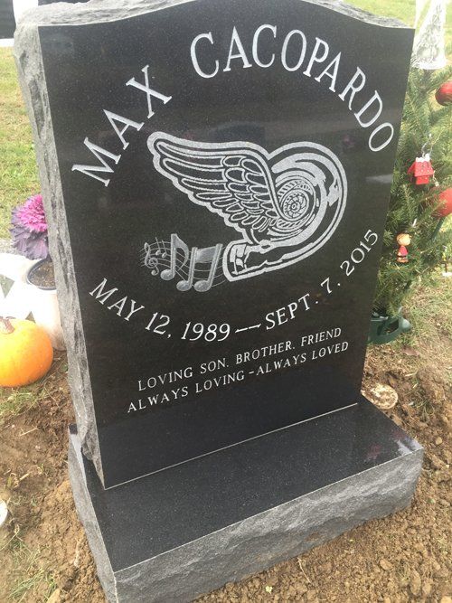 Black granite monument with a laser etched winged wheel and musical notes