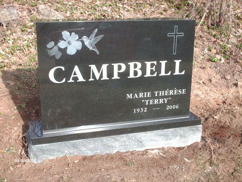 Black granite monument etched with a hummingbird, a flower and a cross